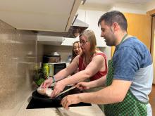 Usuaris de la llar de suport a la cuina preparant el dinar